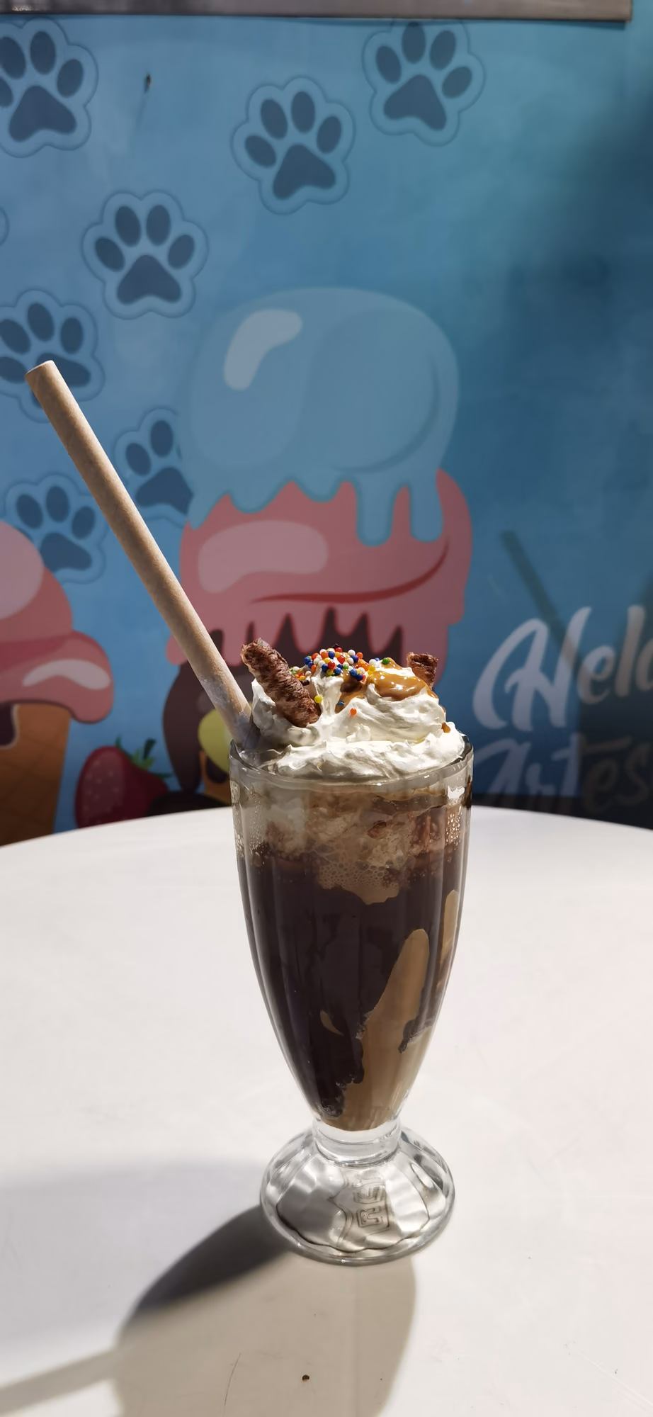 Copa alta con batido, crema batida y bombilla de papel